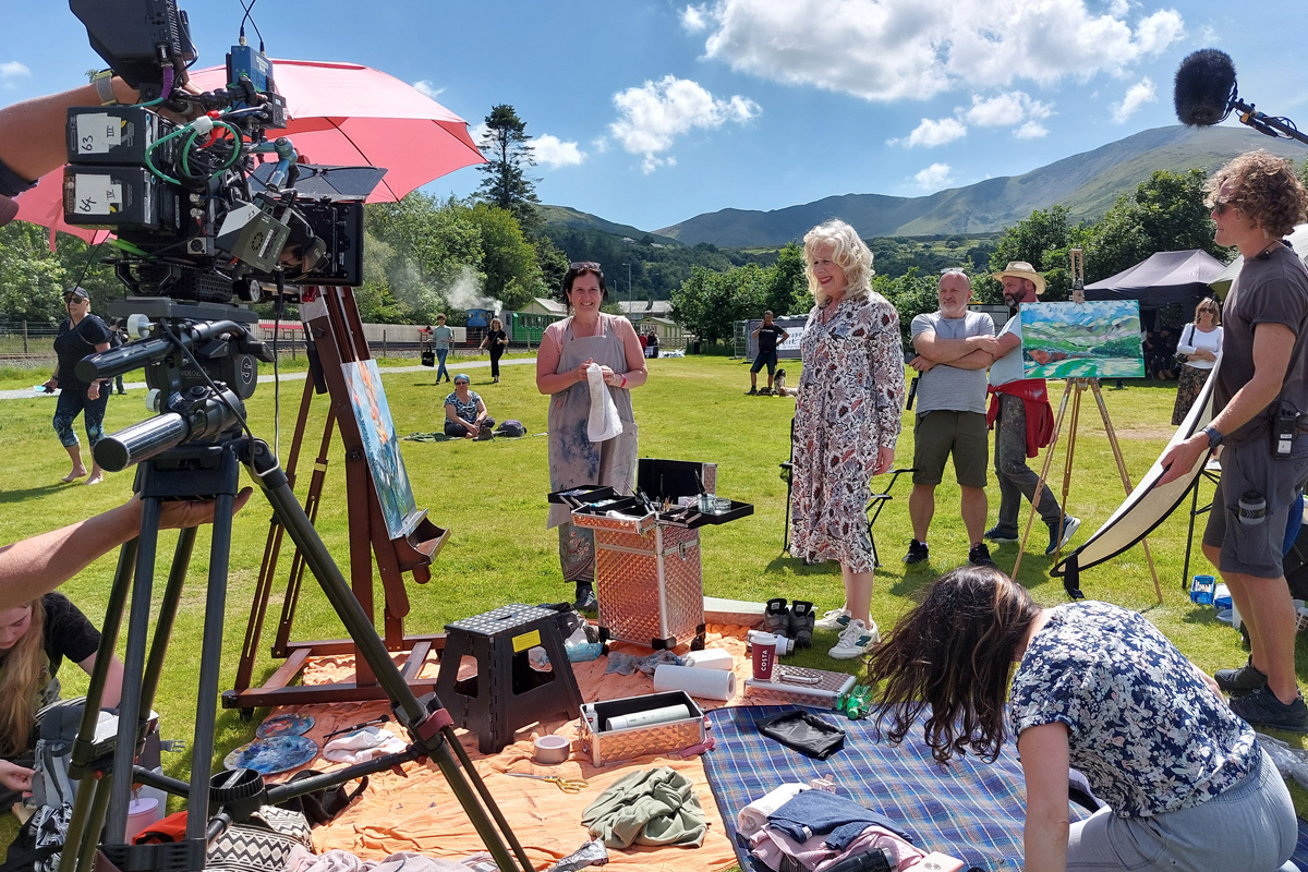 Kathleen Soreano, interviewing a Wildcard contestant surrounded by onlookers and production staff.